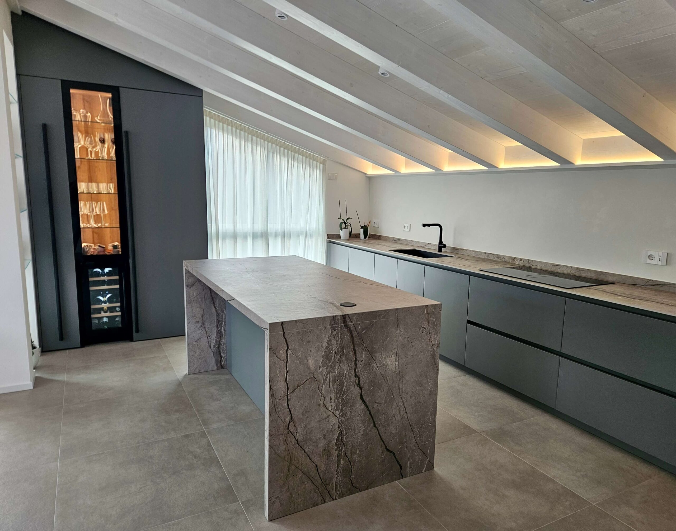 Cucina moderna con isola centrale in pietra e arredi su misura, progetto di interior design